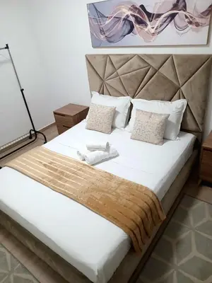 a bedroom with a large white bed with a headboard at Luxury Apartment With Swiming Pool in Hivernage Marrakech in Marrakech