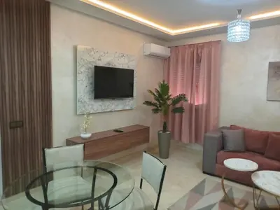 a living room with a couch and a glass table at Luxury Apartment With Swiming Pool in Hivernage Marrakech in Marrakech