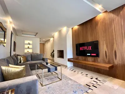 a living room with a couch and a tv on a wall at Prestigia Apart 29 in Marrakech