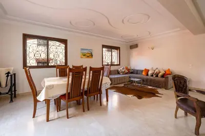 a living room with a table and chairs and a couch at Beautiful Central Marrakech Villa in Marrakech