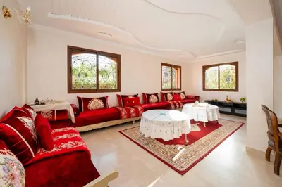 a living room with a red couch and a table at Beautiful Central Marrakech Villa in Marrakech