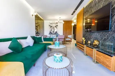 a living room with a green couch and tables at Appartement prestigia Jad in Marrakech