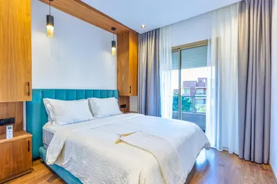 a bedroom with a large bed and a large window at Appartement prestigia Jad in Marrakech