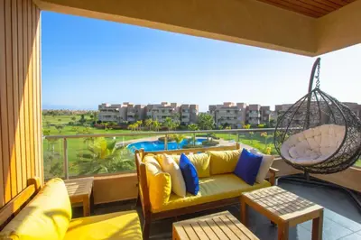 a balcony with a couch and a swing at Appartement prestigia Jad in Marrakech