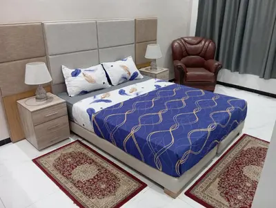 a bedroom with a bed and a chair and two rugs at Marrakech -giliz in Marrakech