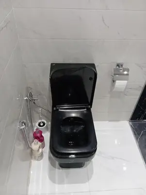 a bathroom with a black toilet in a stall at Marrakech -giliz in Marrakech