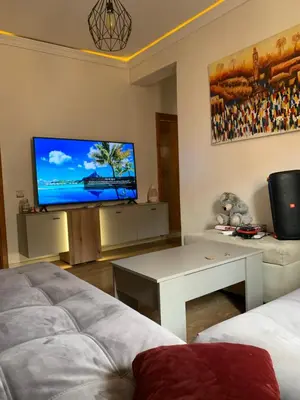 a living room with a couch and a tv at Cosy & chill home in Marrakech