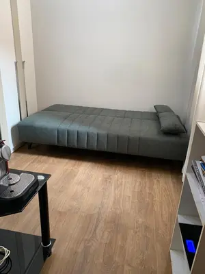 a bed sitting in a room with a wooden floor at Cosy & chill home in Marrakech