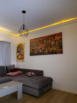 a living room with a couch and a painting on the wall at Cosy & chill home in Marrakech