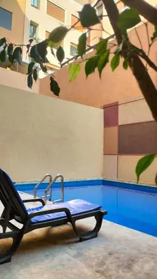 a lounge chair sitting in front of a building at Nid douillet dans la ville Rose in Marrakech