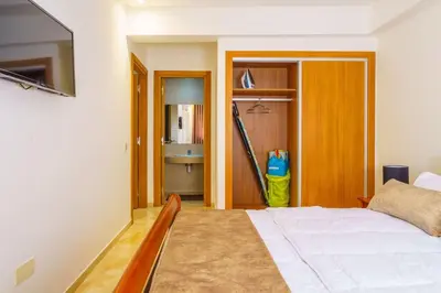 a bedroom with a white bed and a bathroom at Luxury Appartement Cosy 2BR City center Secure Parking Wifi in Marrakech