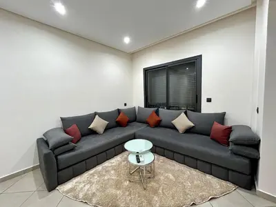 a living room with a gray couch with red pillows at Stylisches City-Apartment im Herzen von Marrakech Gueliz in Marrakech