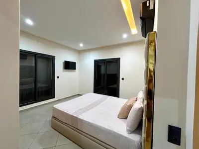 a bedroom with a bed and two large windows at Stylisches City-Apartment im Herzen von Marrakech Gueliz in Marrakech