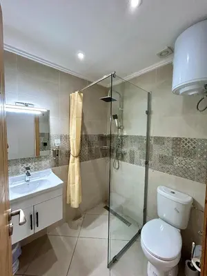 a bathroom with a shower and a toilet and a sink at Stylisches City-Apartment im Herzen von Marrakech Gueliz in Marrakech