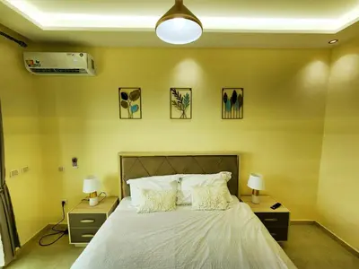 a bedroom with a large bed with two night stands and two lamps at Residence Blida Gueliz 2 Chambres in Marrakech