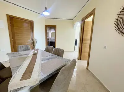 a dining room with a wooden table and chairs at Residence Blida Gueliz 2 Chambres in Marrakech