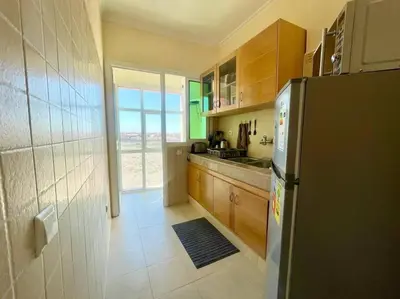 a kitchen with a black refrigerator and a window at Residence Blida Gueliz 2 Chambres in Marrakech