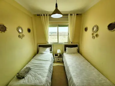 two beds sitting in a room with a window at Residence Blida Gueliz 2 Chambres in Marrakech