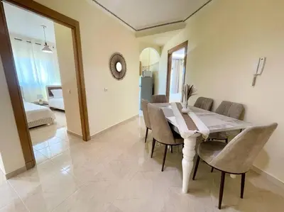 a dining room with a wooden table and chairs at Residence Blida Gueliz 2 Chambres in Marrakech