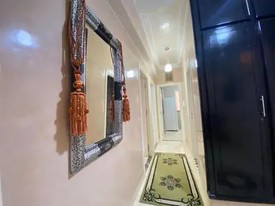 a hallway with a mirror and a rug next to a door at Appart élégance Gueliz in Marrakech