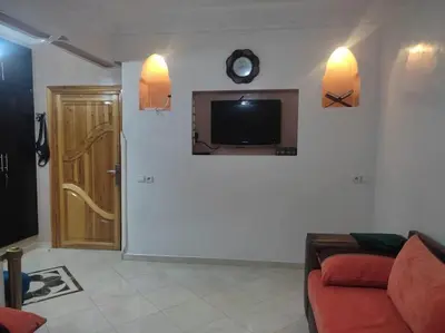 a living room with a couch and a tv on a wall at Appart élégance Gueliz in Marrakech