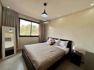 a bedroom with a large bed with a window at Appartement luxe type Suite hôtel Hivernage in Marrakech