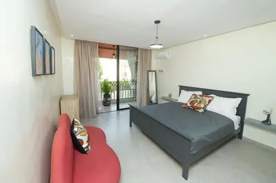 a bedroom with a bed and a red couch at Appartement luxe type Suite hôtel Hivernage in Marrakech