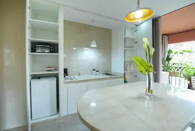 a kitchen with a table with a vase of flowers on it at Appartement luxe type Suite hôtel Hivernage in Marrakech