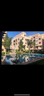 a large apartment building with a pool in front of it at Studio T2 vu sur piscine in Marrakech