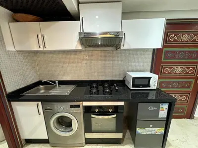 a kitchen with a stove and a washing machine at Studio T2 vu sur piscine in Marrakech