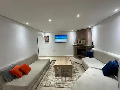 a living room with a couch and a table at Studio T2 vu sur piscine in Marrakech