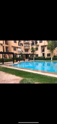 a large swimming pool in front of a building at Studio T2 vu sur piscine in Marrakech