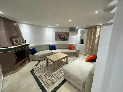 a living room with a couch and a table at Studio T2 vu sur piscine in Marrakech