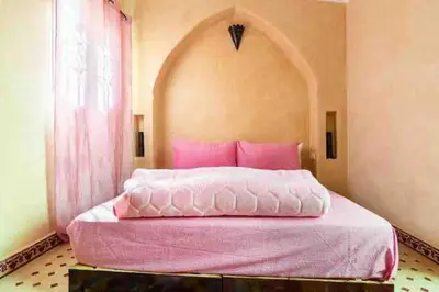 a pink bed in a room with a window at Al Qaria Assiyahia Riad Fadil 44 in Marrakech