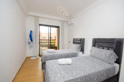 a bedroom with two beds and a window at Cosy flat - gueliz residency in Marrakech