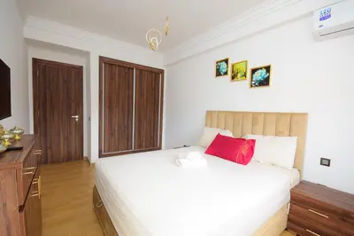a bedroom with a large bed with a red pillow at Cosy flat - gueliz residency in Marrakech