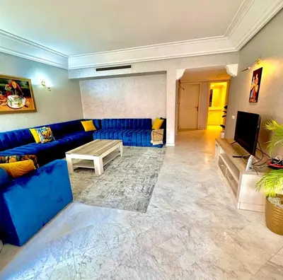 a living room with a blue couch and a tv at bel appartement résidence atlas hivernage in Marrakech