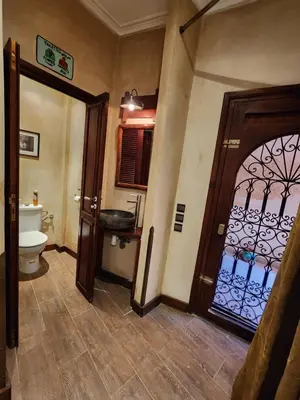 a bathroom with a door and a toilet and a sink at Riad Mumtaz Marrakech in Marrakech