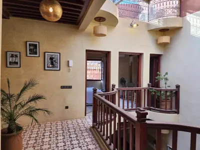a hallway with a wooden staircase and aoyer with a staircase at Riad Mumtaz Marrakech in Marrakech