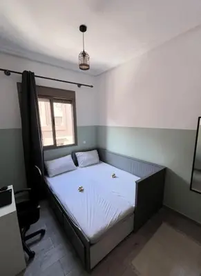 a bedroom with a bed with two pillows and a window at Proche Gueliz T3 Piscine Parking Wifi in Marrakech