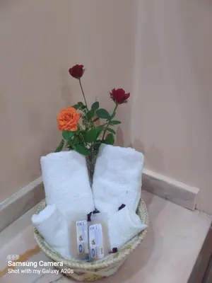 a vase filled with roses sitting on top of towels at اقامة حمزة in Marrakech