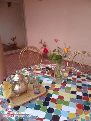 a table with a colorful floor with a vase of flowers at اقامة حمزة in Marrakech