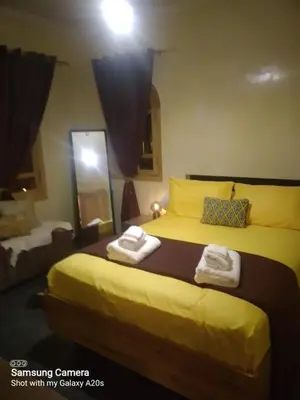 a bedroom with a yellow bed with towels on it at اقامة حمزة in Marrakech