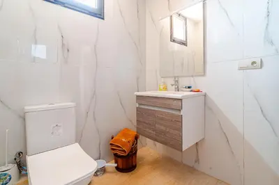 a white bathroom with a toilet and a sink at Duplex romantique Esprit palais à Gueliz in Marrakech