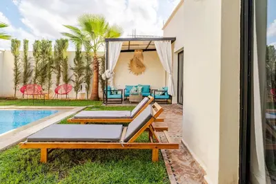 a patio with two lounge chairs and a pool at Villa michlo in El Makina