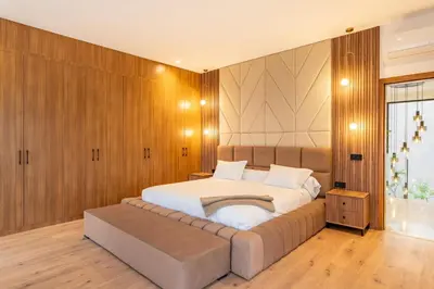a bedroom with a large white bed with a bench at Villa Piscine, Salle de Sport et Confort Moderne in Marrakech