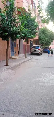 a street with trees and a car parked on the street at Nassim 298 in Marrakech