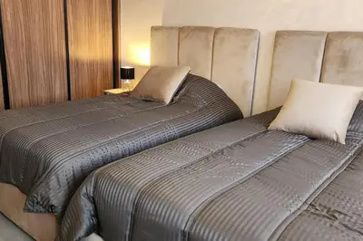 two beds sitting next to each other in a bedroom at Luxury Condo in Downtown Hivernage Neighborhood in Marrakech