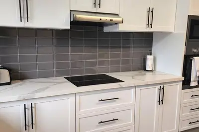 a kitchen with white cabinets and a stove top oven at Luxury Condo in Downtown Hivernage Neighborhood in Marrakech