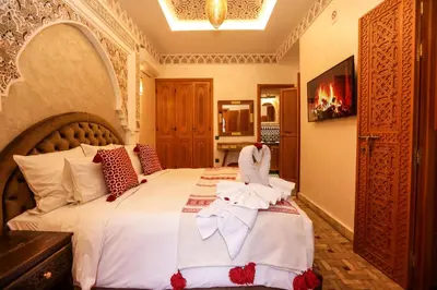 a bedroom with a large bed with white sheets at Riad Palais MERYEM in Marrakech